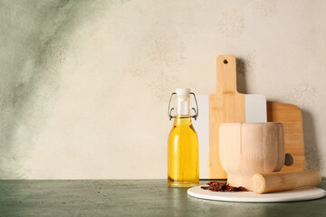 Obraz na płótnie Canvas Healthy cooking and culinary preparation, wooden mortar and pestle with olive oil bottle and dried chili peppers on kitchen counter for home recipes