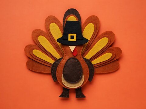 Handmade felt turkey craft for Thanksgiving on vibrant orange background