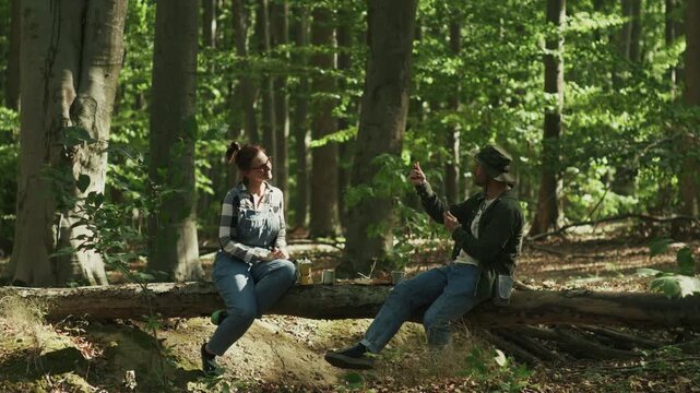 Man Taking Photo of Woman with Smartphone during Coffee Break in Forest