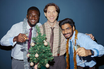 Portrait of diverse young adult businessmen celebrating Christmas party with champagne glasses....
