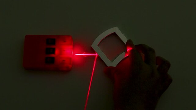 Optics Experiment Demonstrating Red Laser Refraction and Reflection with Concave Lens