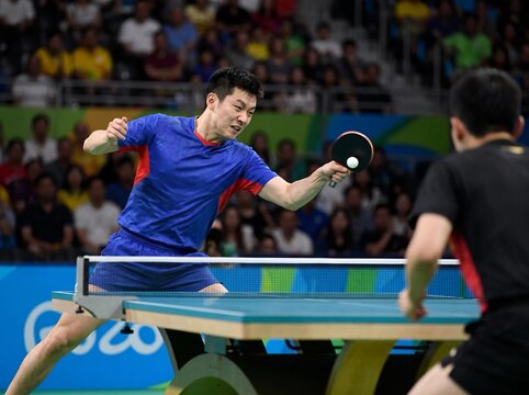 Professional table tennis players during dynamic match in arena stadium