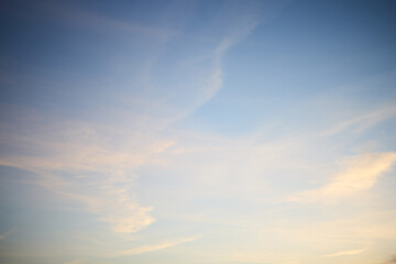 Fototapeta premium Pastel Evening Sky with Soft Clouds and Contrails, Natural Background with Copy Space
