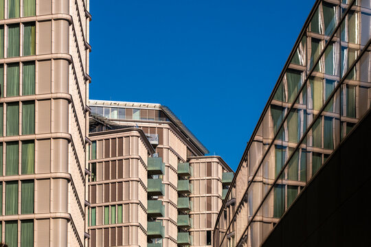 Angular contemporary buildings with warm facades create geometric architecture in Vienna Austria against blue sky in this view of the buildings