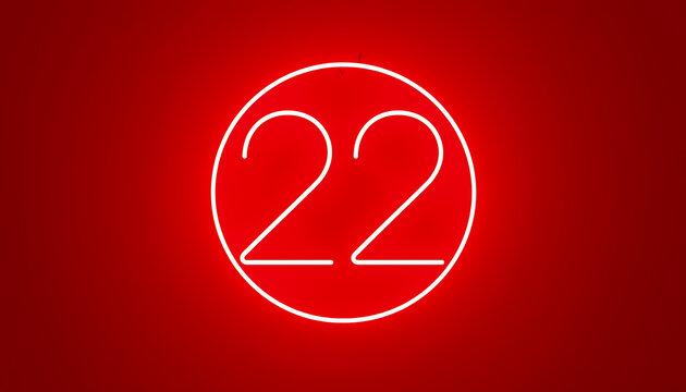 A minimalist neon sign displaying the number 22 inside a circle against a vibrant red background