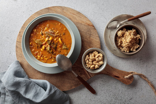 Vegan mung bean curry with oat rice is served on a wooden board