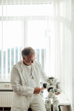 Doctor interacting with a humanoid robot in a bright hospital clinic