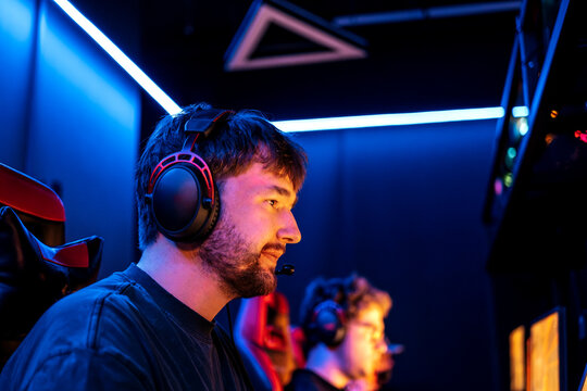 A man plays an online video game with a headset