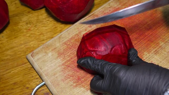 Fresh beet slicing, organic vegetable preparation on wooden board. High-angle static shot.