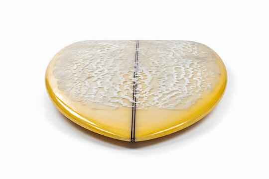 A yellow surfboard with a textured white wax pattern on the deck, featuring a black center stringer, isolated on a plain white background surface