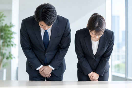 オフィスで丁寧にお辞儀するビジネスパーソン