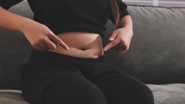 Overweight woman body with hands touching belly fat