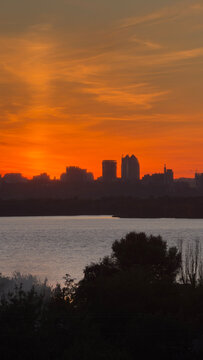 Dnipro City skyline with river, dramatic orange sunset dusk landscape