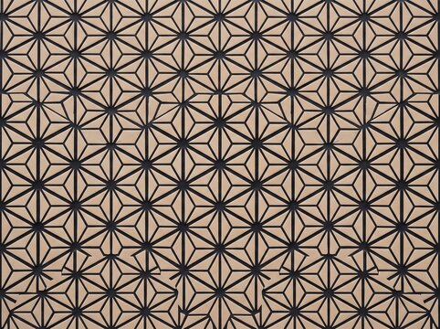 Detailed close-up photograph of a Japanese tile mosaic featuring an intricate repeating geometric pattern of interlocking star shapes and triangles in beige and dark tones