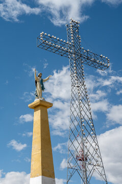 Huancayo, Peru (Per&uacute;) : The Virgin Mary statue stands beside the illuminated Cruz de la Paz on Cerro Achkamarca above Huancayo. The monumental metal cross and Marian statue rise against a blue sky.