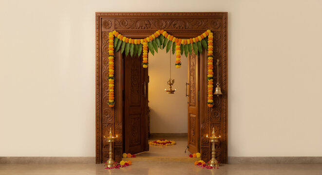raditional Indian Doorway Entrance with Festive Floral Decoration, Lit Oil Lamps and Hanging Brass Diya for Diwali and Dussehra