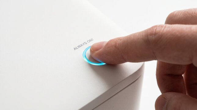 Finger pressing a glowing blue power button next to the text always on on a white modern appliance.