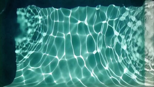 Shimmering turquoise swimming pool water with abstract light patterns and reflections.