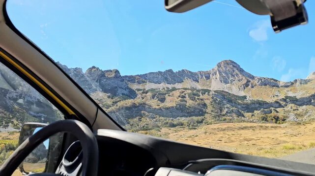 Horizontal slow motion b-roll pov shot from inside a car driving through scenic Sedlo pass in Durmitor Montenegro