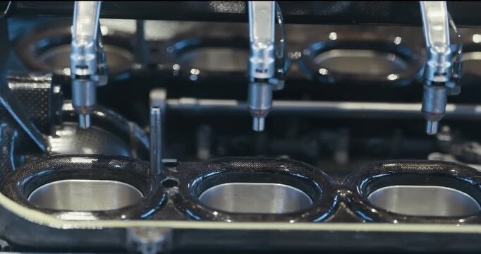 A close up of a sport car engine with a black and silver color scheme. The engine is in the process of being assembled