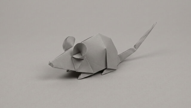 Grey origami paper mouse isolated on a matching grey background