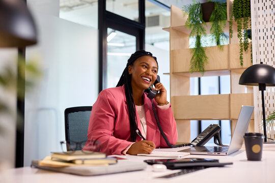 Successful african business woman talking on phone in office