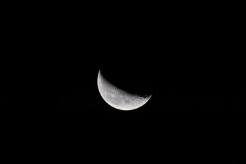 Waning Crescent Moon In Dark Black Night Sky Close Up © Maksim Mikhailov