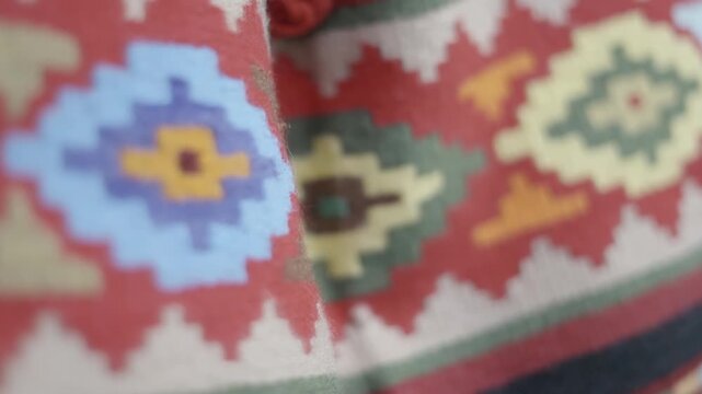 Detail of colorful rugs with a traditional pattern of triangles and squares