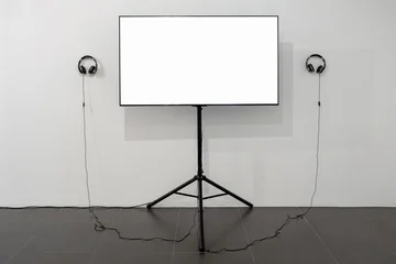 Modern video art exhibition mockup with monitor and two earphones © BOOCYS