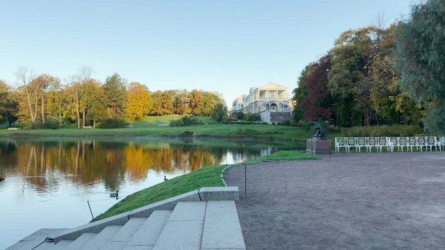 The Cameron Gallery stands proudly on a hill reflecting in calm waters. A quiet path creates a serene autumn feeling. Shot in Catherine Park, Pushkin, Saint Petersburg.