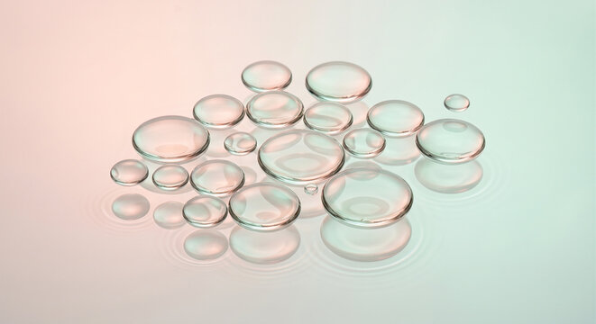 Cluster of clear water drops condensed on a smooth surface with soft pink and blue pastel gradient background