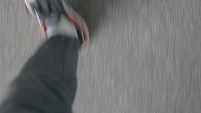 First-person view of person walking on train platform and stepping over yellow safety line at platform edge while heading to boarding area, motion blur from quick steps.