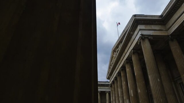 British Museum facade and colonnade appear beneath dramatic clouds in London, United Kingdom