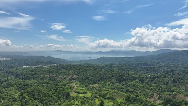 Panoramic view of a natural area with Lake Ilopango in the background, surrounded by lush vegetation and mountainous scenery