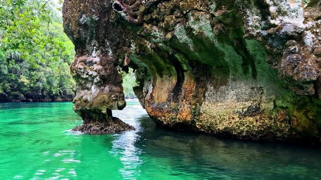 Boat moving through the stunning turquoise lagoon of Sohoton Cove National Park in the Philippines