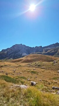 Vertical ultra wide angle slow motion b-roll of majestic rocky mountains under bright sun on Sedlo pass Montenegro