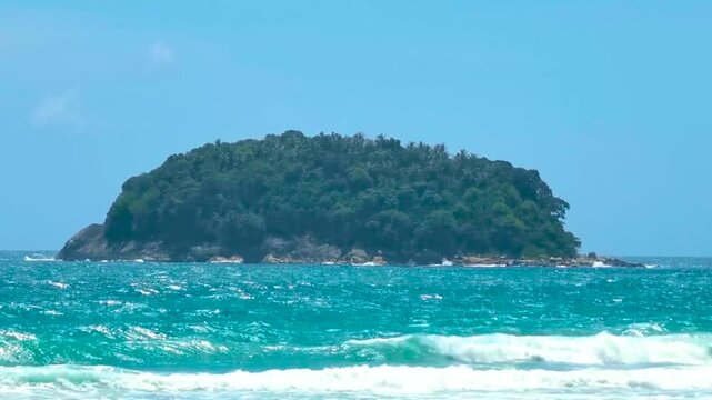 Tropical Ko Pu Island beach turquoise waves sand jungle palms blue sky Kata Beach Phuket Thailand.