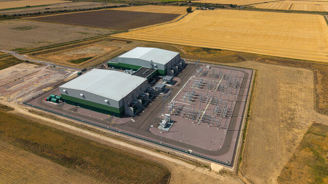 Aerial view of the Viking Link HVDC Converter Station, featuring industrial buildings and electrical infrastructure surrounded by agricultural fields in Donington, England, United Kingdom.