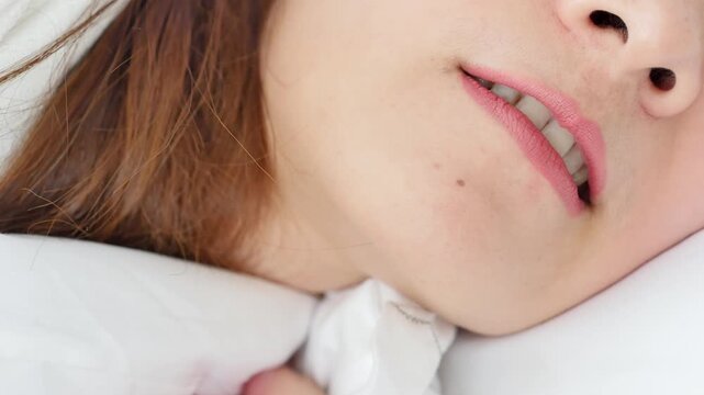 Asian 30s adult woman grinding her teeth, bruxism symptoms; concept image for oral, dental care medical concept, indoor home scene, mouth closeup shot