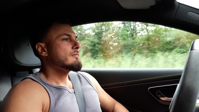 Focused Young Athletic Man Driving Luxury Car on Highway Road Trip Transport and Driver Lifestyle Concept