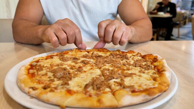 Close Up Man Hands Taking Slice of Hot Fresh Baked Tuna Pizza with Melted Mozzarella Cheese at Restaurant Table Italian Cuisine Dining Concept