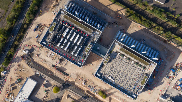 Aerial view of the Data4 Hanau data center facility, featuring large industrial buildings with rooftop cooling units, surrounding construction site, and access roads in Hanau, Hessen, Germany.