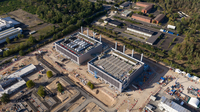 Aerial view of the Data4 Hanau data center construction site, featuring large industrial buildings with rooftop cooling units, surrounding access roads, and cleared land in Hanau, Hessen, Germany.