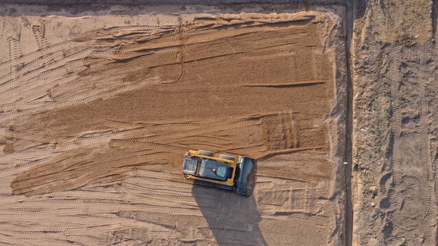 Aerial view of a yellow bulldozer leveling dirt at a construction site in Eaton, Colorado, United States.