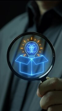 Hand holding magnifying glass vertical shot inspecting glowing brain lightbulb rising from open box. Think outside the box strategy, creative breakthrough innovation, and genius intellect concept.