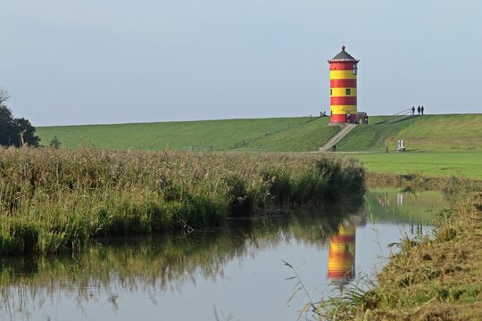 Der Pilsumer Leuchtturm in Ostfriesland mit Spiegelung