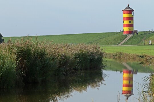 Der Pilsumer Leuchtturm in Ostfriesland mit Spiegelung