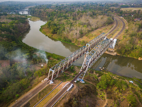 Aerial view of the Progo Railway Bridge spanning the river, surrounded by lush tropical vegetation and trees in Yogyakarta, Special Region of Yogyakarta, Indonesia.
