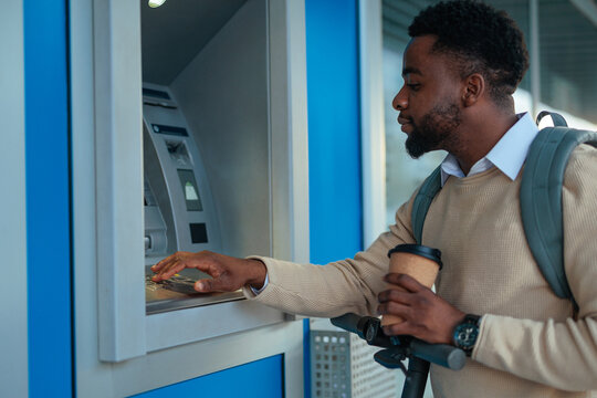 Man using ATM for banking transaction in city
