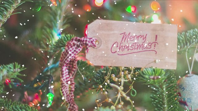 A Christmas tree decorated with hanging cards reading "Merry Christmas," tied with ribbons in warm tones. 